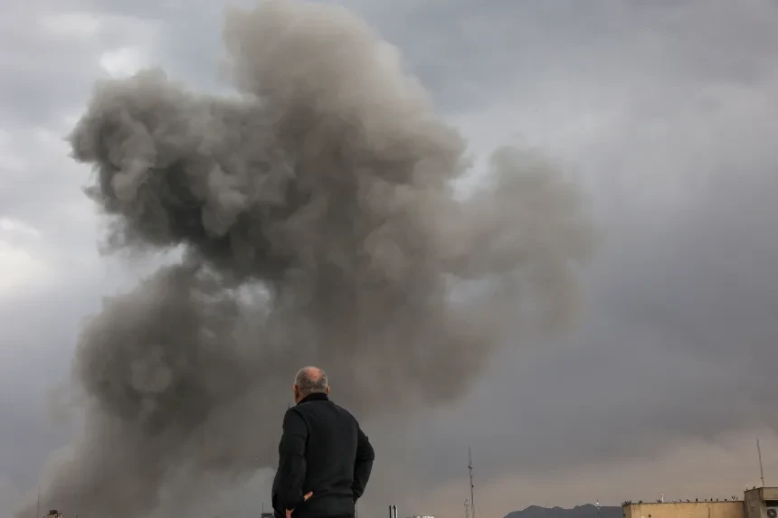 شخص ينظر إلى الدخان المتصاعد في أعقاب انفجار، بعد أن شنت إسرائيل والولايات المتحدة ضربات على إيران، وسط الصراع الأمريكي الإسرائيلي مع إيران، في طهران، يوم الاثنين. رويترز